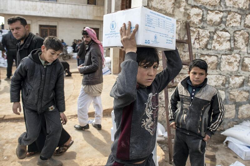 IDLIB, SYRIA - FEBRUARY 19: A displaced Syrian boy carries a box of humanitarian aid supplied by an NGO on February 19, 2020 in Idlib, Syria. Turkey‚Äôs President Recep Tayyip Erdogan said in a speech on Tuesday that he would order ‚Äúimminent operations in Syria‚Äôs Idlib if Damascus fails to withdraw behind Turkish positions‚Äù. The threat comes after Syria‚Äôs government and its ally Russia rejected demands to pull back to ceasefire lines agreed upon in the 2018 Sochi accord. More than 900,000 civilians have been displaced by fighting in or around Idlib since December 1. Idlib is the last rebel stronghold of fighters trying to overthrow Syrian President Bashar al-Assad and in the past years has become the last safe haven for civilians displaced by fighting in other areas of Syria, its population has doubled to close to three million people, many of whom are now fleeing the government offensive towards overcrowded camps close to the Turkish border amid freezing conditions, creating a humanitarian disaster. (Photo by Burak Kara/Getty Images)
