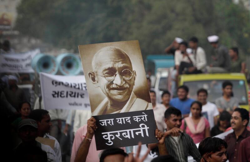 Indian supporters of anti-corruption activist Anna Hazare hold a portrait of Mahatma Gandhi as they protest against corruption in Ahmadabad, India, Thursday, Aug.18, 2011. The renowned Indian anti-corruption crusader struck a deal with police Thursday to hold a 15-day public hunger strike against graft, ending a standoff at a New Delhi prison in which he turned his brief detention into a sit-in protest. Hindi in center reads "Remember the sacrifice"  (AP Photo/Ajit Solanki) *** Local Caption ***  India Corruption Protest.JPEG-0acb9.jpg