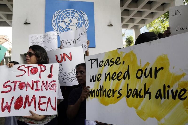 Sri Lankan human rights activists hold placards during a protest against a Saudi death by stoning sentence of a migrant worker accused of adultery MA Pushpa Kumara/EPA