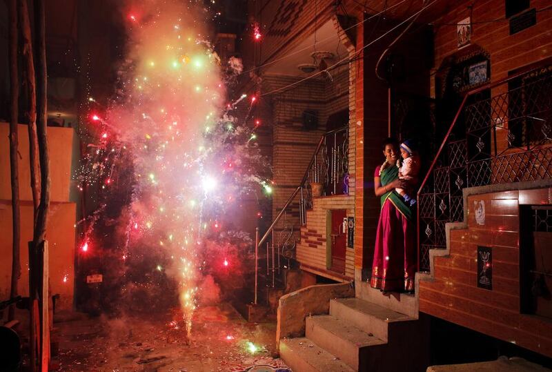 An Indian woman holds her child and watches a firecracker light up in New Delhi on October 23, 2014, the day of Diwali, the annual Hindu festival of lights. Altaf Qadri / AP
