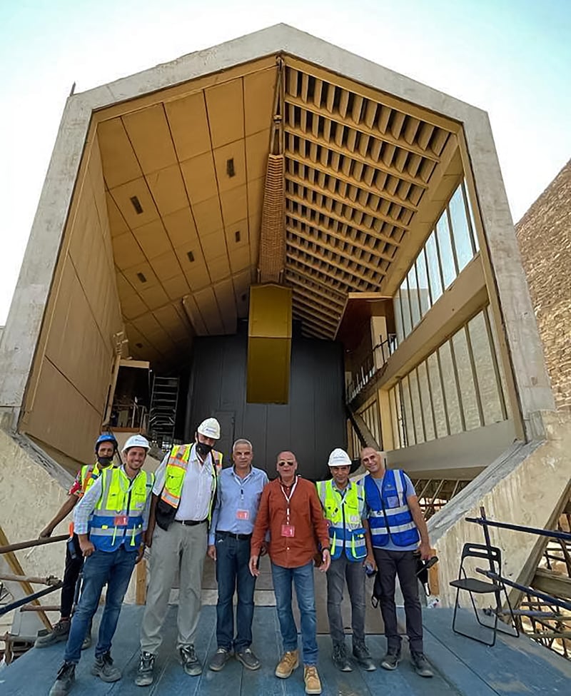 Engineers pose for a group photo outside the old museum home of Pharaoh Khufu's solar barque after the vessel has departed for its new home.