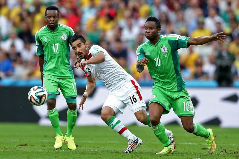 Iran forward Reza Ghoochannejhad, centre, fights for the ball with Nigeria midfielder Ogenyi Onazi and Nigeria midfielder John Obi Mikel, right, during their 2014 World Cup Group F match on Monday. Behrouz Mehri / AFP