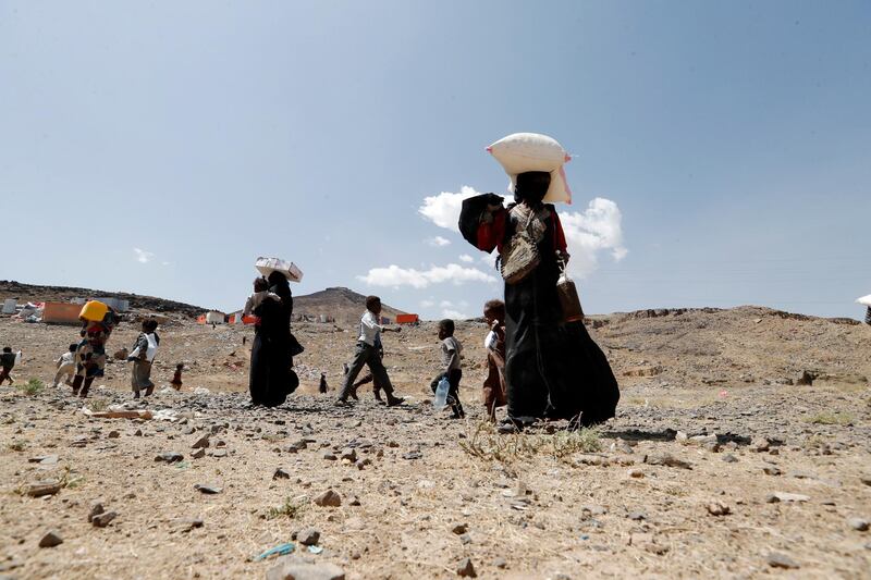 epa09044828 Displaced Yemenis carry their food rations provided by Mona Relief Yemen ahead of an international donors conference on Yemen, at a camp for Internally Displaced Persons (IDPs) in Sana'a, Yemen, 01 March 2021. The United Nations is launching an international donors conference on Yemen Humanitarian Response Plan to address a humanitarian crisis in the war-torn country, warning that over 16 million people, more than half of Yemen's population, would go hungry in 2021, with already some half a million people living in famine-like conditions.  EPA/YAHYA ARHAB