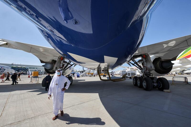 A man walks beneath the underbelly of the Boeing 777X demonstration aircraft at the 2021 Dubai Airshow.  AFP