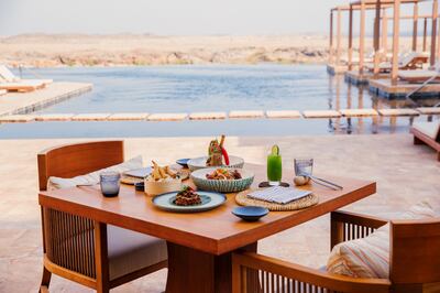 An outdoor table comes with views of the infinity pool, bay and mountains beyond. Photo: Alila Hinu Bay