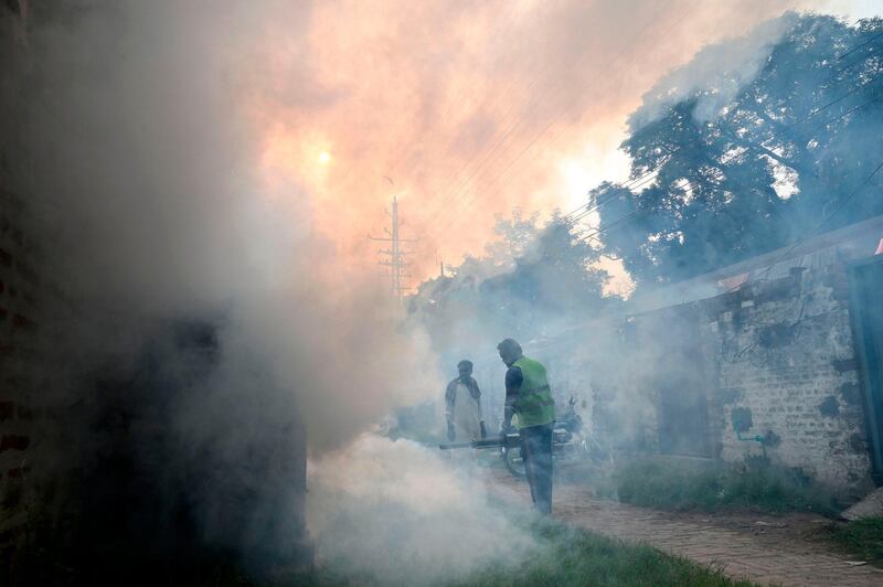 A worker fumigates to kill mosquito larvae to fight against the spread of dengue fever in an area of Lahore. AFP