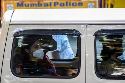 In this picture taken on September 8, 2020, Bollywood actress Rhea Chakraborty (L) sits in a police car after being arrested by the Narcotics Control Bureau (NCB) in Mumbai. Bollywood actress Rhea Chakraborty has been arrested for allegedly buying drugs for her former boyfriend, the actor Sushant Singh Rajput, whose suicide sparked a media storm in India. / AFP / Bhushan KOYANDE
