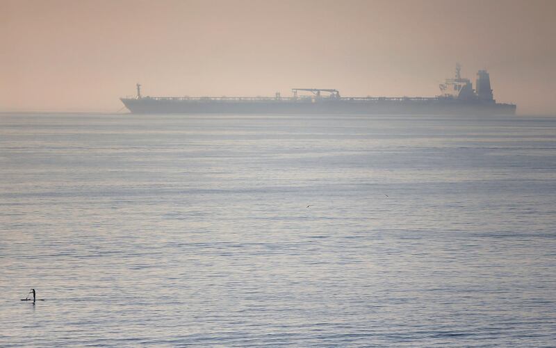 A man paddles on a surfboard near the Iranian oil tanker Grace 1 as it sits anchored after the Supreme Court of the British territory lifted detention order yesterday, in the Strait of Gibraltar, Spain August 16, 2019. REUTERS/Jon Nazca