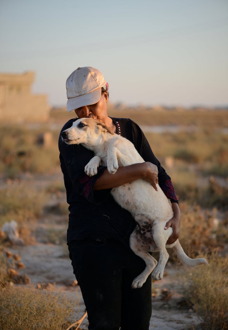 Ms bin Omran pets one of the dogs in Benghazi.