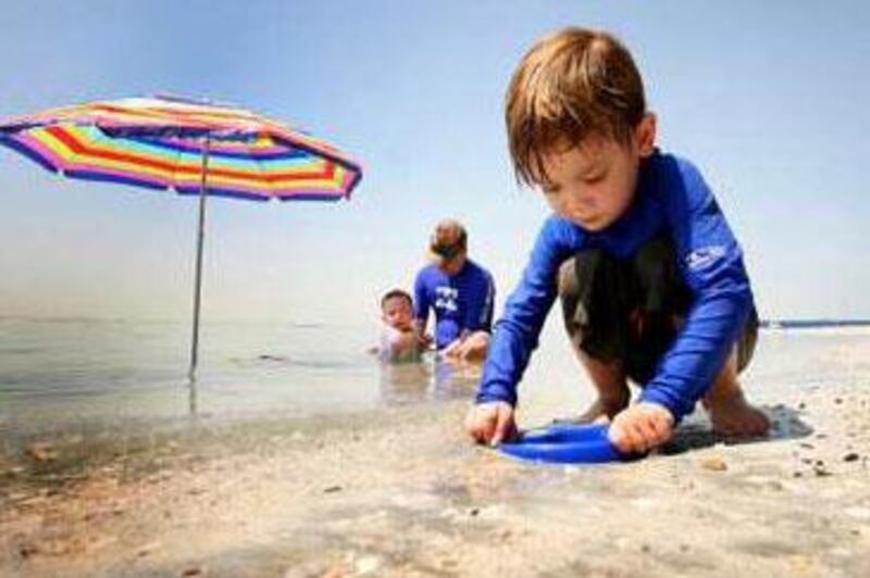 A child plays on the beach along the Abu Dhabi coast: The Masdar Institute is hoping the region's next big renewable fuel source will be grown with an unconventional input: seawater.