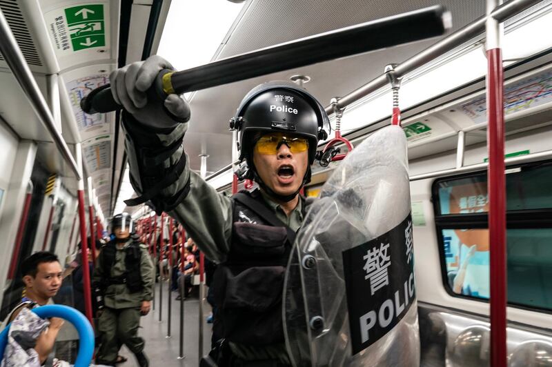 Police charge in a train at the Tung Chung MTR station after protesters block transport routes.   Getty