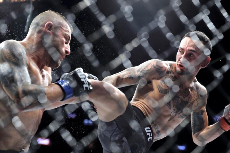 LAS VEGAS, NEVADA - DECEMBER 14: UFC featherweight champion Max Holloway (R) kicks Alexander Volkanovski in their title fight during UFC 245 at T-Mobile Arena on December 14, 2019 in Las Vegas, Nevada. Volkanovski took the title by unanimous decision.   Steve Marcus/Getty Images/AFP