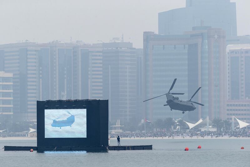 A CH-47 Chinook helicopter circles in front of the crowds on the Corniche after having dropped a special forces team in a low flying manoeuvre. Antonie Robertson / The National