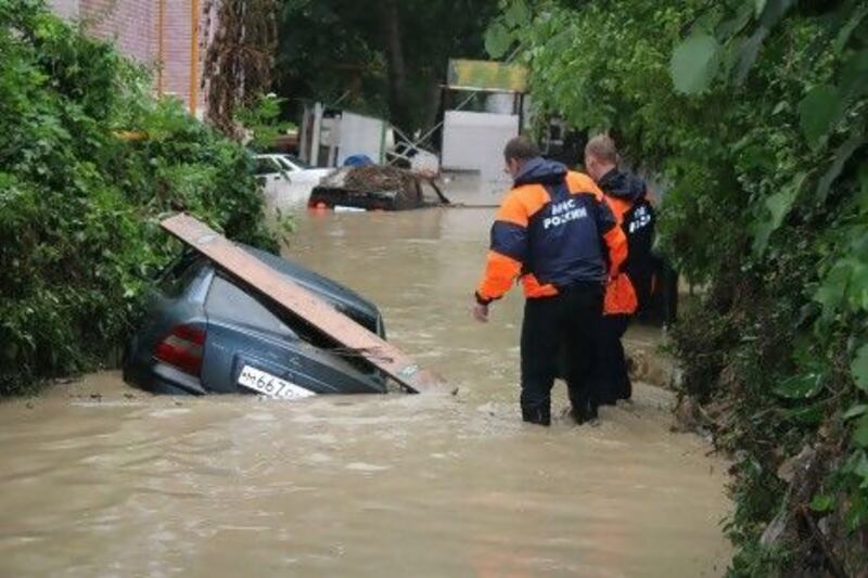 A Ministry of the Emergencies handout shows workers examining an overturned car in floodwaters in Krymsk in Russia's Krasnodar region.