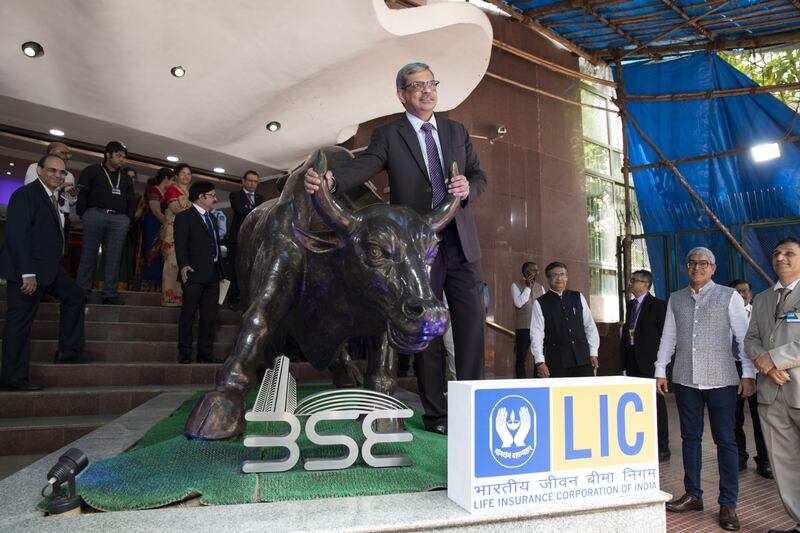 M. R.  Kumar, chairman of LIC, poses with the bull statue at the company's listing ceremony at the Bombay Stock Exchange in May 17. State-run insurer's shares have plunged since its trading debut. Bloomberg