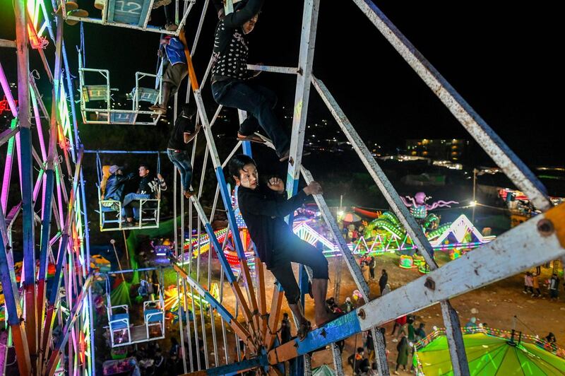 Aung Sein Phyo, 22, and other crew members operating a human-powered ferris wheel in Taunggyi, Shan state. Myanmar's human-powered big wheels, is reliant on gravity-defying agility and split-second coordination by its workforce of youngsters at fairgrounds and festivals across the country. AFP