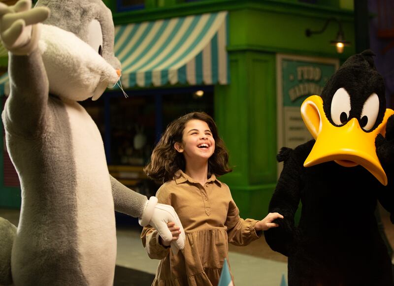Clara walks with Bugs Bunny and Daffy Duck at Warner Bros World Abu Dhabi.