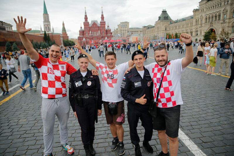 Croatia's supporters pose with police officers in Moscow on July 10, 2018 a day prior the semi-final match England v Croatia during the Russia 2018 World Cup football tournament. / AFP / Maxim ZMEYEV
