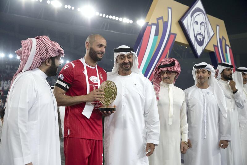 AL AIN, UNITED ARAB EMIRATES - April 18, 2019: HH Sheikh Mohamed bin Zayed Al Nahyan Crown Prince of Abu Dhabi Deputy Supreme Commander of the UAE Armed Forces (3rd L) stands for a photograph with an Etoile du Sahel player after Etoile du Sahel won the 2018–19 Zayed Champions Cup, at Hazza bin Zayed Stadium. Seen with HE Turki bin Abdul Mohsen Al Sheikh, Chairman of the General Entertainment Authority of Saudi Arabia (L), HRH Prince Alwaleed bin Talal bin Abdulaziz Al Saud (4th L) and HH Sheikh Hazza bin Zayed Al Nahyan, Vice Chairman of the Abu Dhabi Executive Council (5th L).

( Mohammed Al Bloushi for Ministry of Presidential Affairs )
---