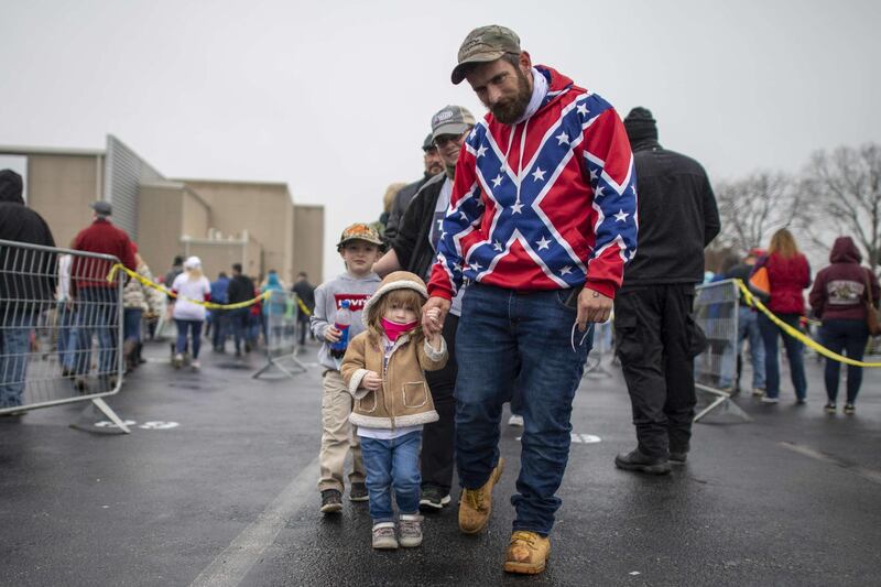 A man wearing a Confederate flag themed sweatshirt walks with his children while queueing before President Donald Trump holds a rally  in Lititz, Pennsylvania. With 8 days to go before the election, Trump is holding 3 rallies across Pennsylvania, a crucial battleground state. AFP