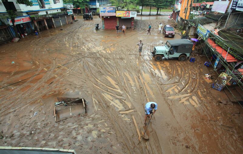 A man clears the sludge in Manimala. EPA