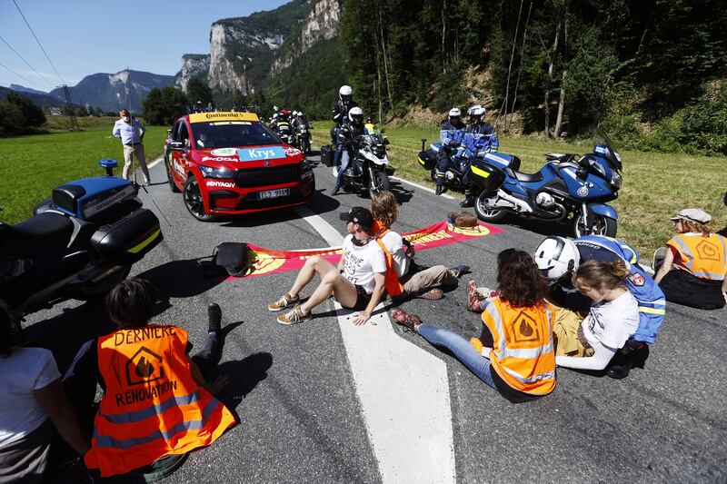 Climate-change protestors block the road during Stage 10. EPA