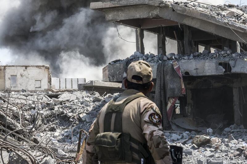 An Iraqi army soldier looks at an Iraqi forces airstrike which targeted an ISIL sniper position in Al Shifa, west Mosul. (Martyn Aim/Getty Images).