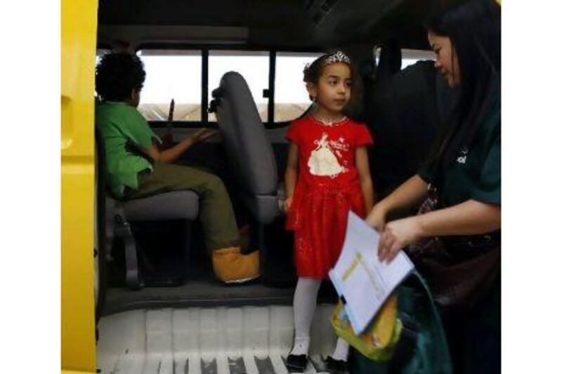 Taaleem provides female staff on its buses. Above, the Falcon Bus Service chaperone Rhona Aquino, right, puts the Jumeirah Baccalaureate School pupil Dania Ali on the bus in Dubai. Amy Leang / The National