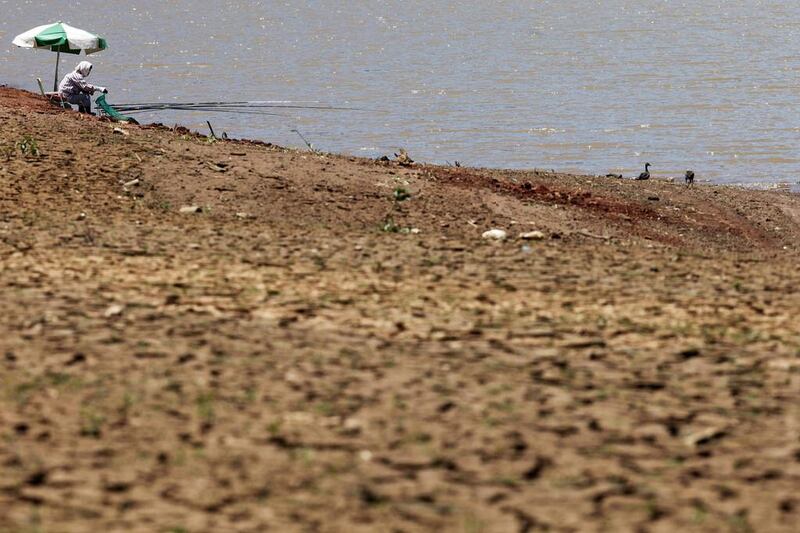 A woman fishes on the coasts of Jaguari dam, part of the Cantareira reservoir. Paulo Whitaker / Reuters