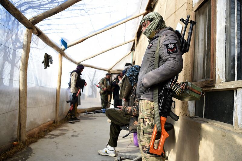 In this photo taken on January 9, 2021, Hazara armed militia for the Resistance for Justice Movement, stand inside their base ahead of a patrol against Taliban insurgents at Hisa-e-Awali Behsud district of Maidan Wardak Province. - Comprising roughly 10 to 20 percent of Afghanistan's 38-million population, Hazaras have long been persecuted for their largely Shiite faith by Sunni hardliners in a country wracked by deep ethnic divisions. (Photo by WAKIL KOHSAR / AFP) / TO GO WITH'Afghanistan-Hazara-violence', by David STOUT, Najiba NOORI