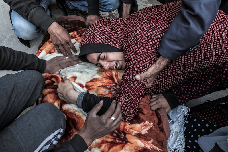 A woman mourns over the body of a loved one, killed during Israeli strikes at Al Aqsa Hospital in central Gaza. AFP