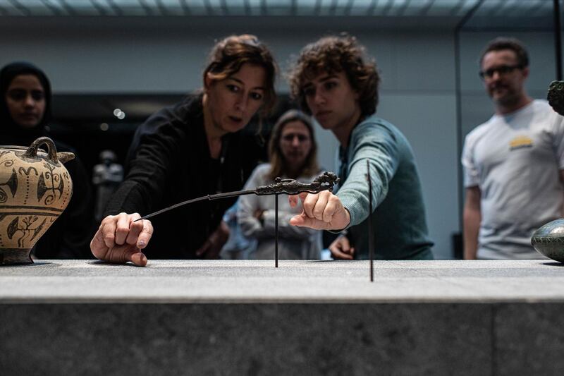 Noemi Dauce, left, curator of archaeology for Louvre Abu Dhabi, inspects the dagger as it goes on display. Courtesy Department of Culture and Tourism – Abu Dhabi