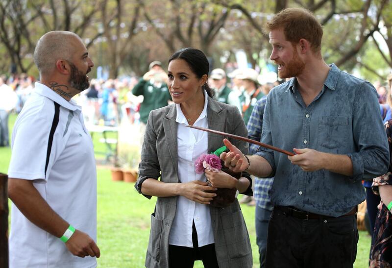 Prince Harry and Meghan are shown a boomerang during a visit to a community picnic at Victoria Park in Dubbo, Australia. AP