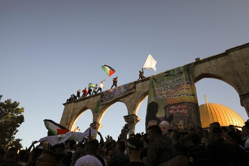 People wave Palestinian flags during Eid al-Fitr prayers, which marks the end of the holy fasting month of Ramadan, at the compound that houses al-Aqsa mosque in Jerusalem's Old City. Reuters