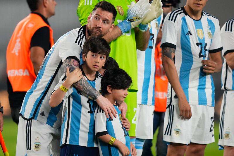 Argentina's Lionel Messi embraces his sons prior to an international friendly soccer match against Panama in Buenos Aires, Argentina, Thursday, March 23, 2023.  (AP Photo / Natacha Pisarenko)