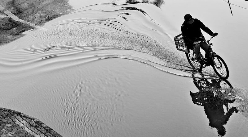 Firos Syed from Qatar won second place with his photograph of a man riding a cycle through a puddle creating ripples in its wake.