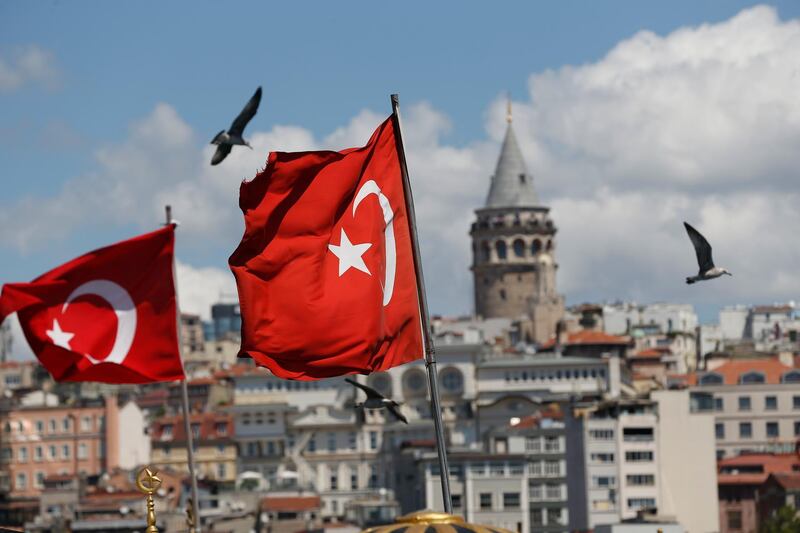 Backdropped by the iconic Galata Tower seagulls fly past Turkish flags in Istanbul, Monday, Aug. 13, 2018. Turkey's central bank announced a series of measures on Monday to free up cash for banks as the country grapples with a currency crisis sparked by concerns over President Recep Tayyip Erdogan's economic policies and a trade and diplomatic dispute with the United States. (AP Photo/Lefteris Pitarakis)