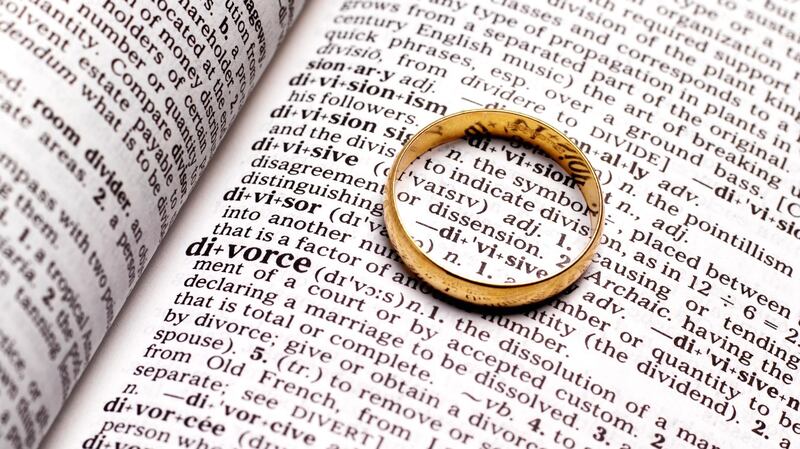 Divorce wedding ring on dictionary. Getty Images