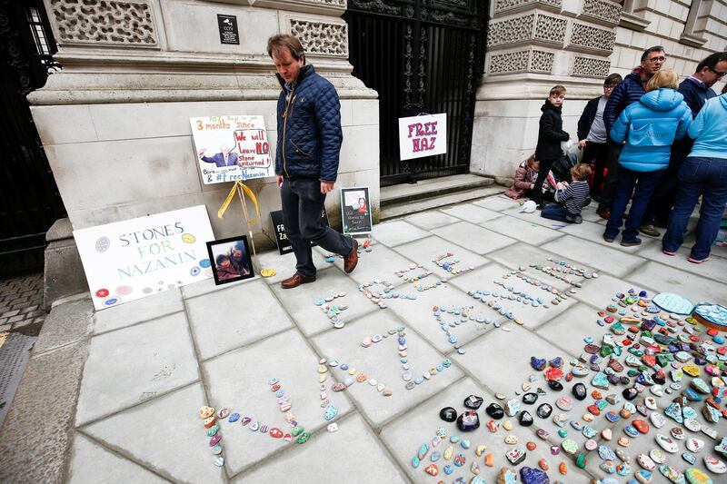 Richard Ratcliffe views stones and placards with messages placed on the pavement outside the Foreign and Commonwealth Office during a demonstration to demand the release of his wife Nazanin Zaghari-Ratcliffe, who is imprisoned in Iran, in London, Britain, March 10, 2018. REUTERS/ Henry Nicholls
