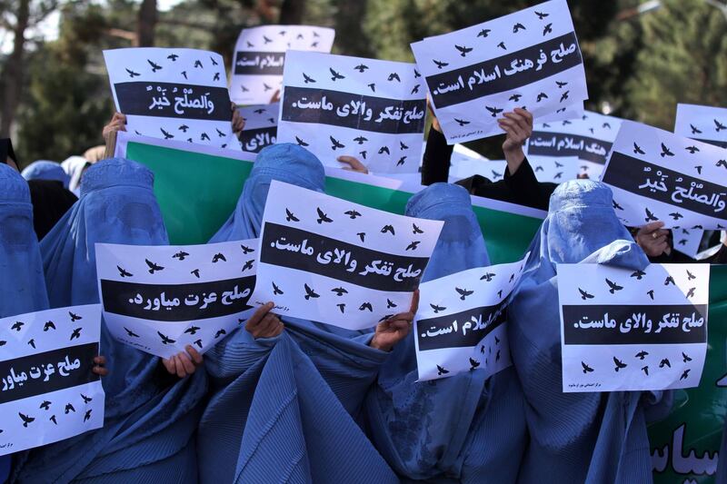 epaselect epa07433548 AAfghan women hold placards reading in Dari 'Peace is our supreme thinking' as they rally to the provincial Governor's compound during a protest against the lack of their representation in a possible peace deal between the Taliban and the US, in Herat, Afghanistan, 13 March 2019. As the US and Taliban negotiate a peace deal, the women from different walks of life in Afghanistan have shown their concerns, as they want to actively participate in all political, social and development initiatives across the country, including in any peace processes.  EPA/JALIL REZAYEE