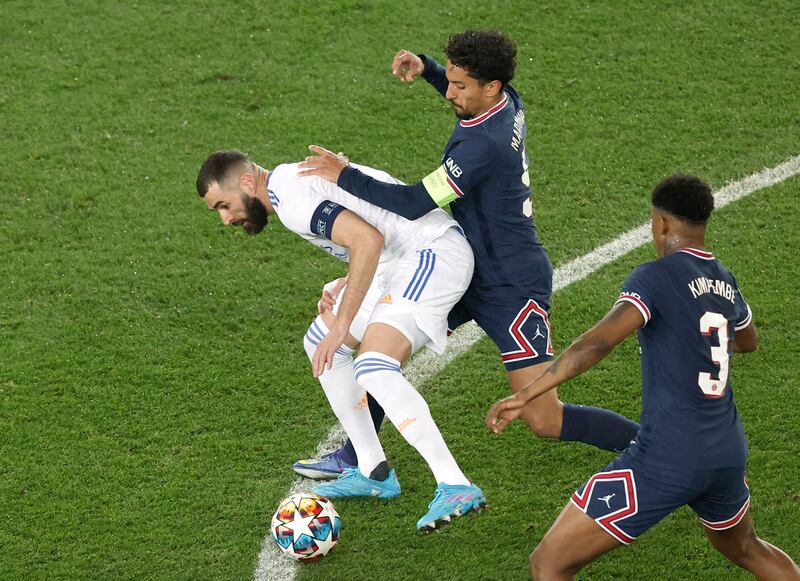 Real Madrid's Karim Benzema tries to break free from Real's Marquinhos. Reuters