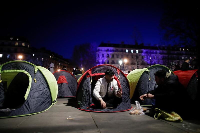 Men chat among the tents. Reuters