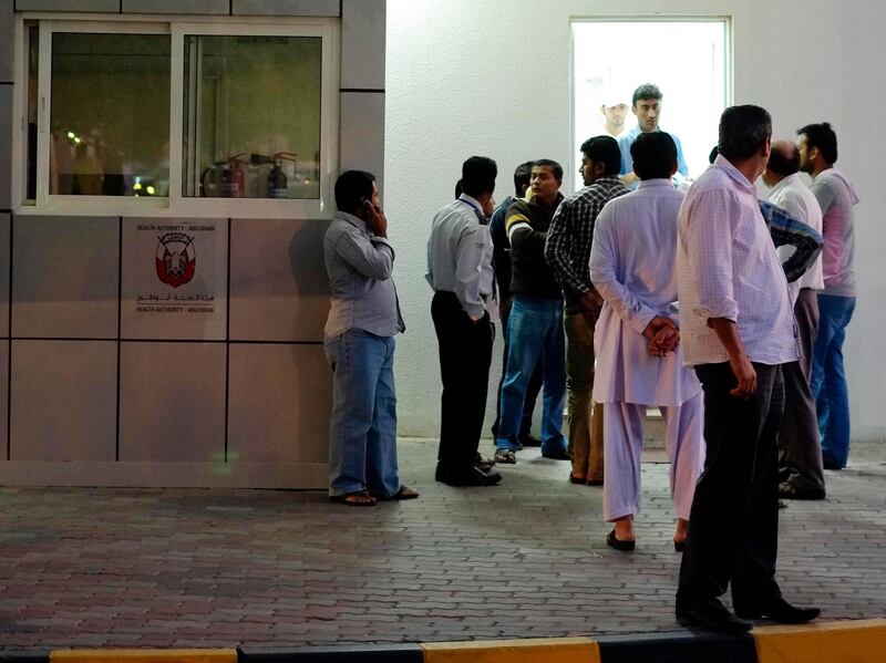 AL AIN, UNITED ARAB EMIRATES,  February 04, 2013. Friends, family and co-workers wait outside the Al Ain Morgue, at the Al Ain Hospital, for news about the deceased in todays accident where a construction truck filled with sand capsized on a bus filled with labourers. (ANTONIE ROBERTSON / The National)