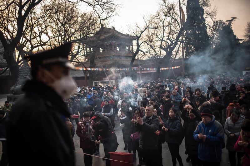 Chinese Buddhist devotees burn incense sticks during prayers at Yonghegong Lama Temple in Beijing, China. EPA