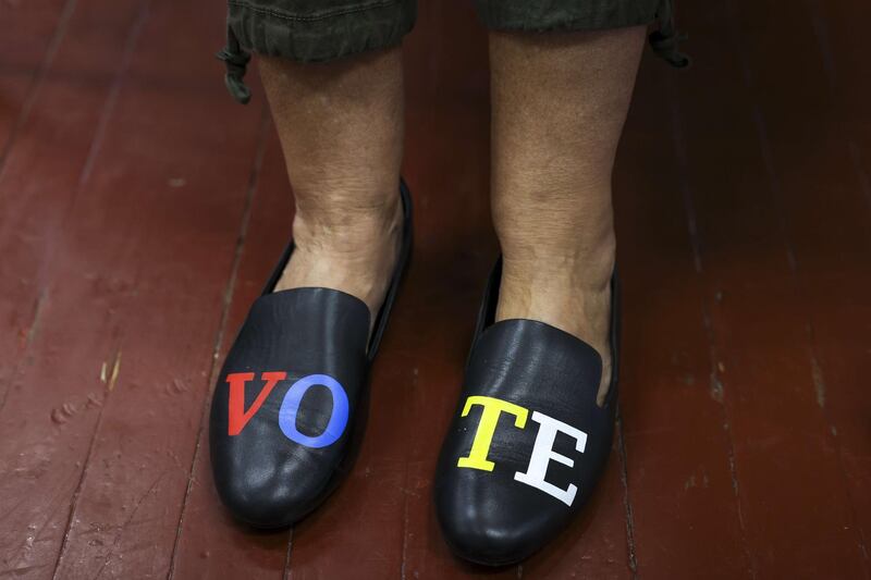 Poll manager Susan Taylor wears shoes with the word 'Vote' as she checks people in to vote at the Hazel Parker Playground on election day in Charleston. AFP