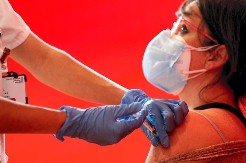 epaselect epa09099960 A health worker injects a dose of the AstraZeneca vaccine against COVID19 to a teacher, in Valencia, eastern Spain, 26 March 2021. Spain resumed the use of this vaccine after a 10-day-long pause in its administration after reports stated the vaccine could be associated with an increase in the risk of blood clotting disorders, doubts that were finally ruled out by the European Union's medicines regulator that declared the vaccine as safe.  EPA/Manuel Bruque