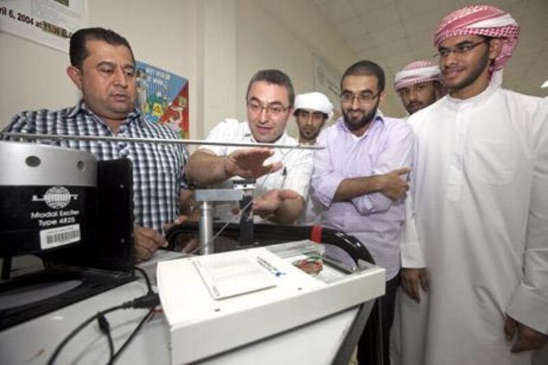 Sharjah - May 18, 2011 - From left electrical engineering professors Dr. Nasser Qaddoumi listens while Dr. Lutfi Albashar talks with students Mohamed Almehrezi, Mohamed Abdelbari, Mansour Bani Hammad and Hadef Al Shamsi about the microchip they are developing for a non contact vibration monitoring system at the American University of Sharjah in Sharjah, May 18, 2011. (Photo by Jeff Topping/The National) 

 