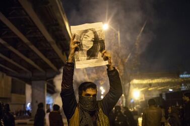 An Iranian man holds a picture of a victim of the Ukrainian Boeing 737-800 plane crash during a demonstration in front of Tehran's Amir Kabir University on January 11, 2020. Demonstrations broke out for a second night in a row after Iran admitted to having shot down a Ukrainian passenger jet by mistake on January 8, killing all 176 people on board. / AFP / STR