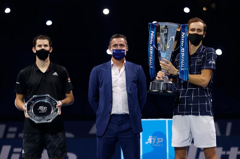 Daniil Medvedev lifts the ATP Finals trophy while Dominic Thiem holds the runners-up plate. Getty Images