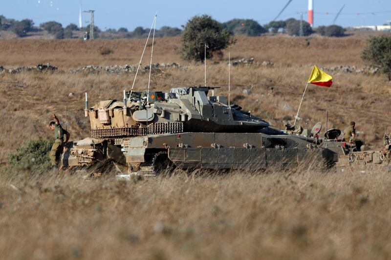 An Israeli soldier jumps off a tank in the Israeli-controlled Golan Heights, near the Israel-Syria frontier August 3, 2020. REUTERS/Ronen Zvulun